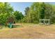 Fun for the whole Gathering in a shady yard featuring a swing set and covered bench at 12842 Plaza Road Ext, Charlotte, NC 28215