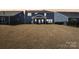 Back of a blue house showing a large backyard with a covered patio and well-maintained lawn at 13102 Petrel Pl, Charlotte, NC 28278