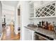 A stylish bar area featuring a wine rack, granite countertop, and a beverage refrigerator at 13102 Petrel Pl, Charlotte, NC 28278