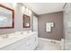 A bathroom featuring double vanity, with matching mirrors, and a glass enclosed shower at 13102 Petrel Pl, Charlotte, NC 28278