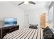Neat bedroom offering a television, ceiling fan, neutral colors and door leading to the bathroom at 13102 Petrel Pl, Charlotte, NC 28278