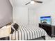 Inviting bedroom featuring a ceiling fan, television, neutral colors, bedside lighting, and modern accents at 13102 Petrel Pl, Charlotte, NC 28278