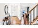 Inviting foyer featuring hardwood floors, a decorative mirror, and a glimpse into the home office at 13102 Petrel Pl, Charlotte, NC 28278
