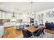 Eat-in kitchen features an island with seating, pendant lighting, stainless appliances and hardwood floors at 13102 Petrel Pl, Charlotte, NC 28278