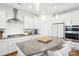 Modern all-white kitchen with stainless appliances, granite countertops and hardwood flooring at 13102 Petrel Pl, Charlotte, NC 28278
