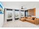 Bright living room with large tan sofa, white carpet, black accent wall and modern ceiling fan at 13102 Petrel Pl, Charlotte, NC 28278