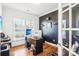 Home office space featuring a sleek desk, dark accent wall, and ample natural light at 13102 Petrel Pl, Charlotte, NC 28278