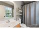 Clean bathroom with a tub/shower, toilet, sink, and natural light from the window at 140 Camforth Dr, Mooresville, NC 28117