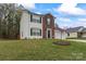 Inviting home with a brick accent, green shutters, a green lawn, and a blossoming tree at 140 Camforth Dr, Mooresville, NC 28117
