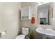 This well-lit half bathroom includes a toilet, sink, mirror, and storage cabinet at 140 Camforth Dr, Mooresville, NC 28117