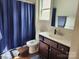 Bathroom featuring a dark wood vanity, white sink, a toilet, and a blue shower curtain at 14022 Clayborn St, Midland, NC 28107