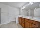 Bright bathroom features a double sink vanity with wood cabinets and a large mirror at 14256 Drake Watch Ln, Charlotte, NC 28262