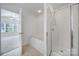Bright bathroom features a separate tub and shower with glass door at 14256 Drake Watch Ln, Charlotte, NC 28262