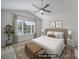 Staged bedroom with a ceiling fan, window, and neutral decor at 14256 Drake Watch Ln, Charlotte, NC 28262