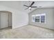Empty bedroom with vaulted ceiling, carpeted floors, and a large window at 14256 Drake Watch Ln, Charlotte, NC 28262