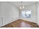 Bright dining room featuring wood floors, chair rail, and a modern chandelier at 14256 Drake Watch Ln, Charlotte, NC 28262