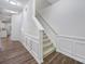 Bright hallway with stairs, wainscoting, and modern lighting at 14256 Drake Watch Ln, Charlotte, NC 28262