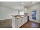 Open kitchen with a breakfast bar, white cabinets, and stainless steel sink at 14256 Drake Watch Ln, Charlotte, NC 28262