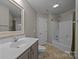 Bathroom featuring large mirror, gray cabinets, a white sink, and a tub/shower at 17301 Glassfield Dr, Huntersville, NC 28078