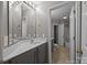Bathroom showcasing large mirror, dark gray cabinets, a white sink, and a tub/shower at 17301 Glassfield Dr, Huntersville, NC 28078