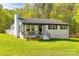 Charming one-story white brick home featuring a covered porch, black accents, and a lush green lawn at 1849 Harris Rd, Fort Mill, SC 29708