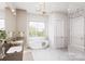 Bright bathroom features double vanity, marble countertops, glass enclosed shower, and soaking tub with a view at 20114 Norman Colony Rd, Cornelius, NC 28031