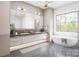 Stunning bathroom featuring a large window, freestanding tub, and a double sink vanity with marble countertops at 20114 Norman Colony Rd, Cornelius, NC 28031
