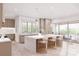 Bright kitchen features a center island with bar stools, custom cabinetry and seamlessly connects to the outdoor balcony at 20114 Norman Colony Rd, Cornelius, NC 28031