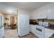 Functional kitchen featuring white cabinets, tile floors, and modern appliances with a view into the adjoining dining area at 206 Cliffside Dr, Kannapolis, NC 28081