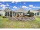 Landscaped backyard with a stone retaining wall, patio, and mature trees at 2158 Hartwell Ln, Fort Mill, SC 29707
