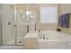 This bright bathroom has a glass-enclosed shower and large soaking tub with a garden view at 2158 Hartwell Ln, Fort Mill, SC 29707