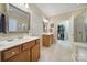 This is the bathroom with double sinks, tile floors, and open door to a walk-in closet and glass-enclosed shower at 2158 Hartwell Ln, Fort Mill, SC 29707