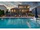 Stunning pool with lounge chairs, ambient lighting, a large stone patio, and outdoor seating at 2220 Gallberry Ln, Waxhaw, NC 28173