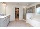 Bright bathroom featuring double vanity, a soaking tub, and a glass-enclosed shower at 2248 Killian Creek Dr, Denver, NC 28037