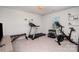 Bright exercise room featuring neutral walls, a treadmill, stationary bike, weight set and lots of natural light at 2248 Killian Creek Dr, Denver, NC 28037