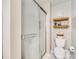 A clean bathroom with a glass shower door, with shelves above the toilet at 236 Greendale Dr, Mount Holly, NC 28120