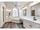 Bright bathroom with an arched window over a soaking tub, white vanities and dark wood-look flooring at 2515 Barrington Ct, Rock Hill, SC 29732