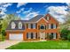 Beautiful two-story brick home featuring a manicured lawn, attached garage, and classic black shutters at 2515 Barrington Ct, Rock Hill, SC 29732