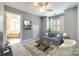 Cozy living room with a blue sofa, neutral carpet, and a view into a bright and spacious bathroom at 2515 Barrington Ct, Rock Hill, SC 29732