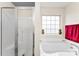 Bright bathroom featuring an enclosed glass door shower, soaking tub, and decorative vases at 2548 Flintshire Ln, Gastonia, NC 28056