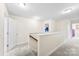 Upstairs hallway with neutral walls and carpet, natural light, and staircase with wooden railing at 2548 Flintshire Ln, Gastonia, NC 28056