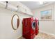 Bright laundry room with red washer/dryer, storage shelves and a decorative oval mirror at 2548 Flintshire Ln, Gastonia, NC 28056
