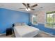 Bright bedroom with a ceiling fan, two windows, and colorful accent wall and patterned wallpaper at 3013 Kensley Dr, Waxhaw, NC 28173
