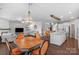 Open-concept living room view showcases a wooden chandelier, kitchen island, staircase, and dining table with chairs at 3013 Kensley Dr, Waxhaw, NC 28173