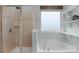 Main bathroom features a glass enclosed shower, a garden tub and frosted window with decor shelving at 3013 Kensley Dr, Waxhaw, NC 28173