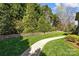 Beautifully landscaped backyard with stone retaining wall and manicured lawn at 318 Montrose Dr, Waxhaw, NC 28173