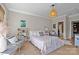 Bright bedroom with light wood floors, a cozy seating area, and an en-suite bathroom for convenience at 318 Montrose Dr, Waxhaw, NC 28173