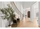 Bright foyer with curved staircase, white wainscoting, and a large plant adding warmth to the space at 318 Montrose Dr, Waxhaw, NC 28173