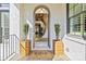 Inviting front entrance with arched doorway, potted plants, and a 'Welcome' mat on the covered porch at 318 Montrose Dr, Waxhaw, NC 28173