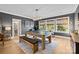 An elegant game room with a ping pong table, comfortable bench seating, and natural light from large windows at 318 Montrose Dr, Waxhaw, NC 28173